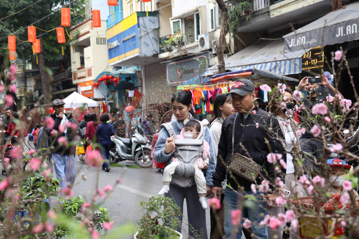 Một gia đình tranh thủ ngày Hà Nội tạnh ráo để đi ngắm hoa tại chợ hoa Hàng Lược.