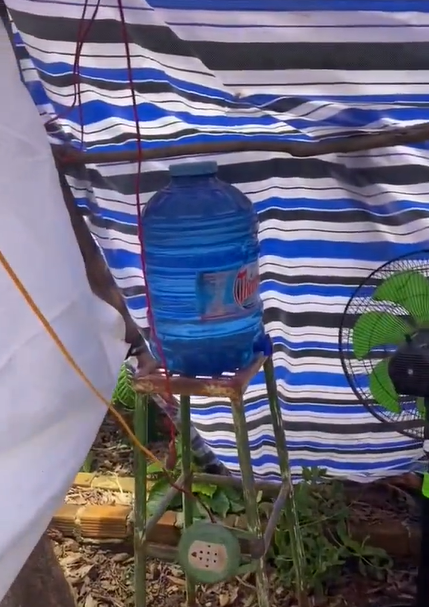 Xa xa, ở khoảng cách giữa túp lều và căn nhà thì đặt sẵn một chiếc ghế nhỏ. Đây sẽ là vị trí để ba mẹ đặt đồ ăn tiếp tế cho cô gái trong thời gian ở nhà cách ly.