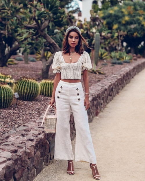 Ở set đồ thứ 2, Annebelle Fleur phối theo công thức matchy -matchy với crop top ren trắng cùng quần ống loe và sandals ton sur ton. Ngoài ra, việc nhấn nhá chiếc túi cói và phụ kiện đội đầu ngọc trai càng khiến tổng thể phong cách của cô thêm phần thu hút.