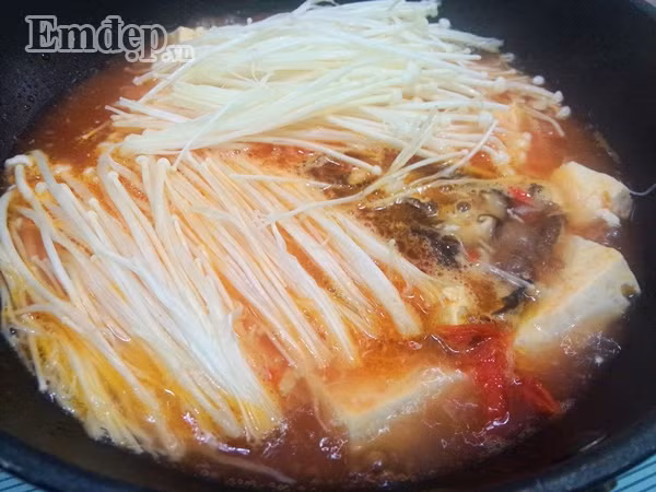 Cho nấm kim châm + nấm hương vào chảo, đảo nhẹ nhàng rồi đun sôi khoảng 3 phút. Tiếp tục cho hành lá + rau mùi thái nhỏ vào đun sôi trở lại rồi tắt bếp.