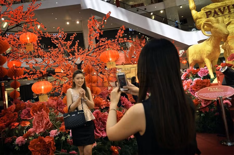 Nữ du khách chụp ảnh kỉ niệm sáng 30 Tết.