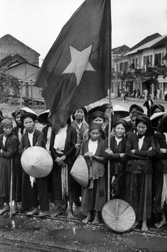 Người dân Hà Nội và lá cờ đỏ sao vàng chào đón đoàn quân chiến thắng trở về tiếp quản Thủ đô trong năm 1954. Nguồn ảnh: Life.