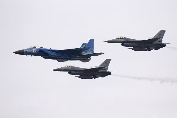 2 tiêm kích F-16 hộ tống phía sau F-15SG. Triển lãm được tổ chức 2 năm một lần này là cơ hội để nước chủ nhà "khoe" thành tựu của lực lượng không quân. Ảnh: Bloomberg.