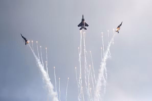 3 chiến đấu cơ của Không quân Singapore vừa thả pháo sáng vừa thực hiện động tác rẽ quạt đẹp mắt. Ảnh: Yahoo News.