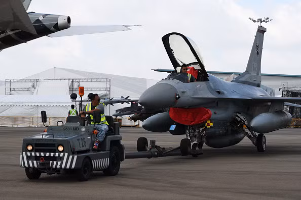 Tiêm kích F-16 của Không quân Singapore đang được kéo ra vị trí trưng bày. Triển lãm năm nay quy tụ khoảng 1.062 công ty và tập đoàn trên thế giới đến trưng bày và giới thiệu sản phẩm. Ảnh: Yahoo News