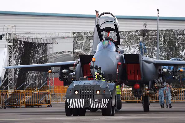 Tiêm kích F-15SG của Không quân Singapore đang được kéo ra vị trí trưng bày. Triển lãm hàng không được tổ chức 2 năm một lần này là cơ hội để không quân các nước trong khu vực quảng bá sức mạnh. Ảnh: Yahoo News