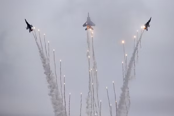 Màn rẽ quạt và thả pháo sáng đẹp mắt của F-15SG (giữa) và 2 chiếc F-16 (hai bên). Ảnh: Bloomberg.