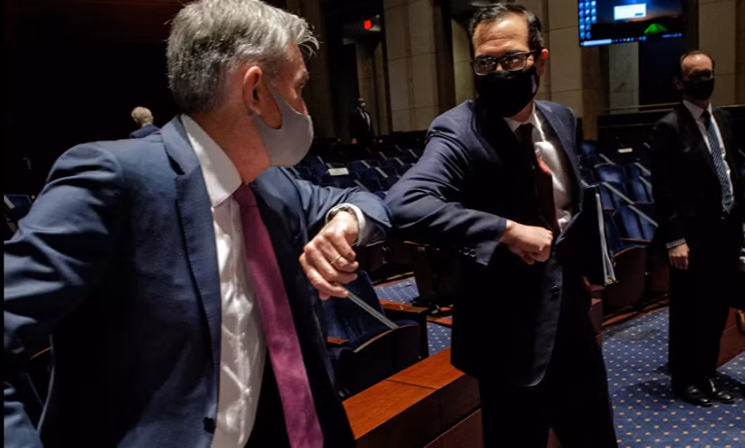 Chủ tịch Cục Dự trữ Liên bang Mỹ Jerome Powell và Bộ trưởng Tài chính Mỹ Steven Mnuchin chào nhau sau phiên điều trần tại Điện Capitol ở Washington ngày 30/6/2020.