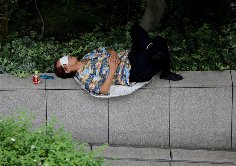 Người đàn ông tranh thủ nằm ngủ trên đường phố ở Tokyo, Nhật Bản, ngày 16/7.