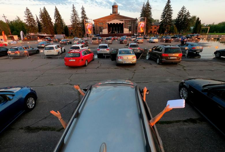 Mọi người ngồi trên ô tô theo dõi buổi biểu diễn của ban nhạc ở Riga, Latvia, ngày 11/6.