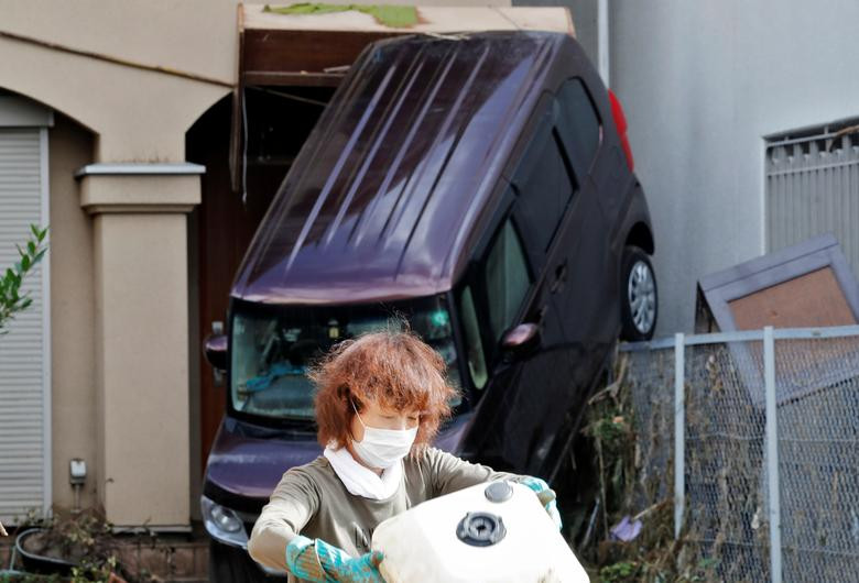 Người phụ nữ thu dọn đống ngổn ngang trước ngôi nhà ở Hitoyoshi.