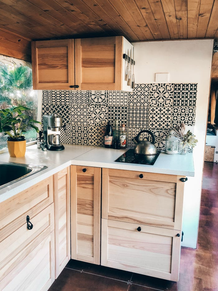 Nhà bếp đơn giản nhưng đầy đủ, có tủ lạnh, bồn rửa và bếp nấu.