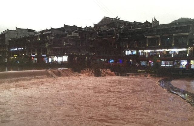 Được biết, từ tối 25/6, Phượng Hoàng cổ trấn, nằm bên một nhánh sông Trường Giang, về phía thượng nguồn đập Tam Hiệp, đã "chìm trong biển nước" đục ngầu do mưa lớn kéo dài. Ảnh: TN. 