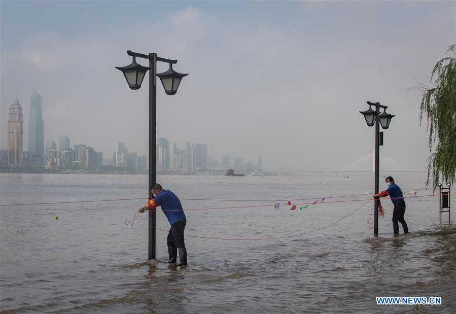 Giới chức trách cho buộc dây thừng vào những cột đèn đường để cảnh báo tại Vũ Hán ngày 6/7. Ảnh: THX.