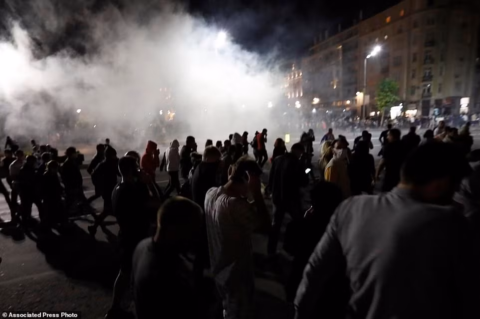 Những người biểu tình tháo chạy trên đường phố sau khi cảnh sát Serbia phun hơi cay.