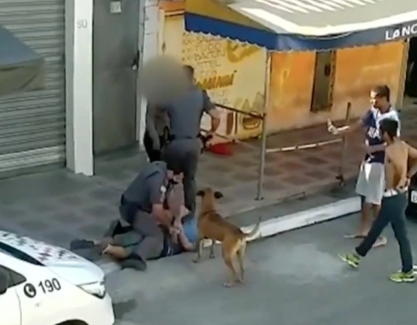 Cũng trong đoạn clip, một cảnh sát Brazil được nhìn thấy đang chĩa súng vào hai người đàn ông dường như không có vũ khí, sau đó bắt giữ họ. Ảnh: The Sun.