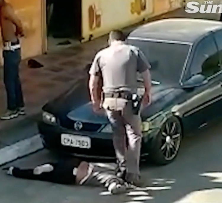 Người phụ nữ 51 tuổi, được cho là chủ quán bar, nằm úp mặt xuống đất và bị cảnh sát giẫm chân lên cổ. Ảnh: The Sun.