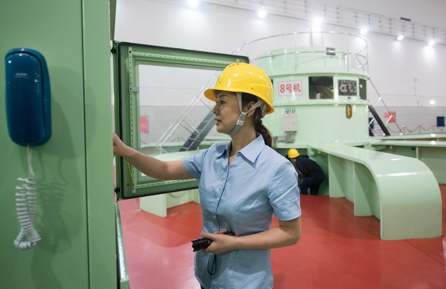 Một nhân viên nhà máy thủy điện kiểm tra hệ thống máy móc. Hồ thủy điện Tân An Giang có 9 cửa xả lũ, mỗi cửa có thể xả nước với tốc độ 500 m3/giây. 5 cửa xả lũ đã được mở trưa ngày 7/7, đến 16h chiều cùng ngày, 7 cửa đã được mở. Ảnh: Tân Hoa Xã.