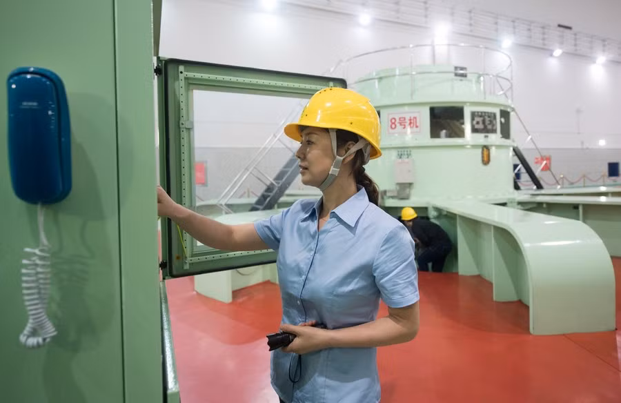 Một nhân viên nhà máy thủy điện kiểm tra hệ thống máy móc. Hồ thủy điện Tân An Giang có 9 cửa xả lũ, mỗi cửa có thể xả nước với tốc độ 500 m3/giây. 5 cửa xả lũ đã được mở trưa ngày 7/7, đến 16h chiều cùng ngày, 7 cửa đã được mở. Ảnh: Tân Hoa Xã.