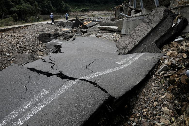 Kiểm tra con đường bị mưa lũ phá hủy ở Kumamura hôm 8/7.