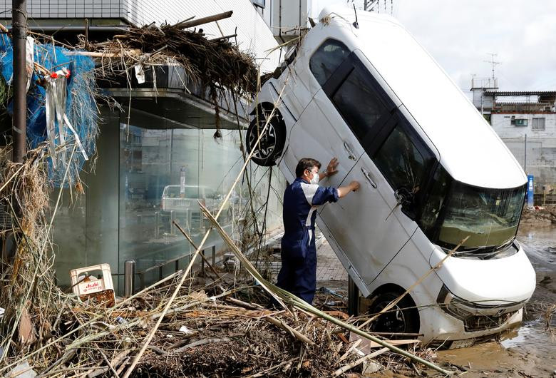 Người đàn ông tìm cách mở cửa chiếc ô tô hư hại sau khi bị nước lũ cuốn trôi tại thị trấn Hitoyoshi, tỉnh Kumamoto, hôm 8/7. Được biết, Kumamoto là một trong những địa phương bị ảnh hưởng nghiêm trọng nhất trong các trận lũ lụt, lở đất do mưa lớn tại nước này.