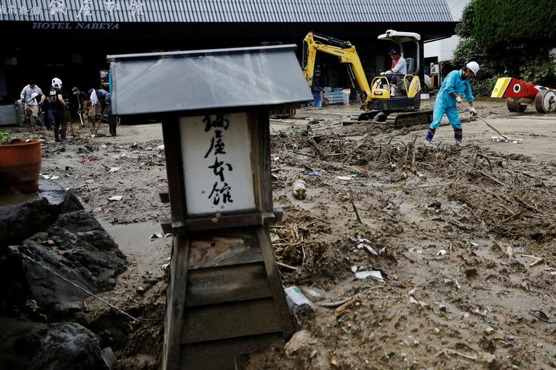 Công nhân dọn bùn đất phía trước một khách sạn ở Hitoyoshi hôm 8/7.