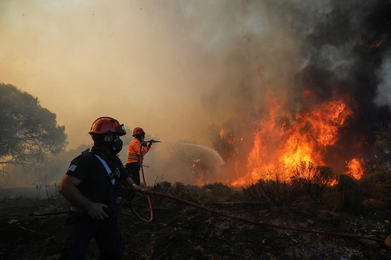 Lính cứu hỏa phun nước dập lửa gần làng Kechries hôm 22/7.