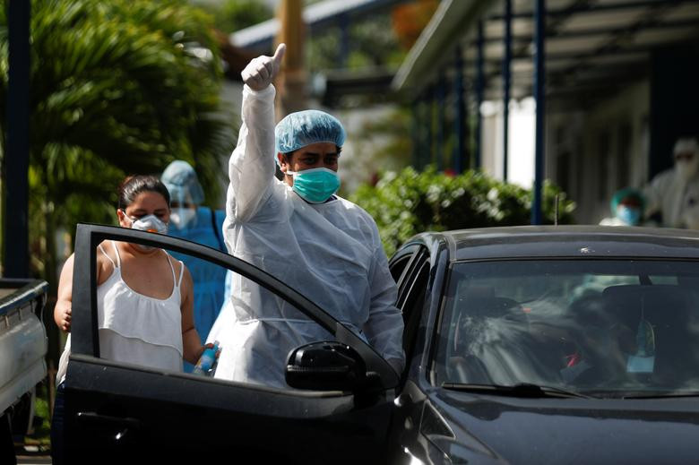 Người đàn ông đeo khẩu trang và mặc đồ bảo hộ khi được xuất viện sau thời gian điều trị COVID-19 tại bệnh viện San Rafael ở Santa Tecla hôm 26/6.