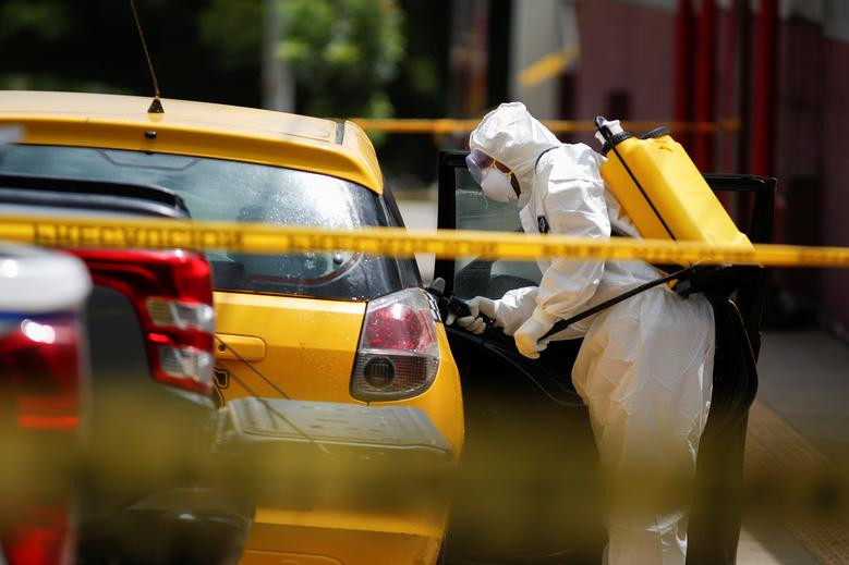 Một nhân viên y tế phun khử trùng chiếc taxi trên đường phố San Marcos, El Salvador, ngày 29/6.