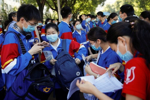 "Cao khảo", kỳ thi đại học thường niên của Trung Quốc, chính thức bắt đầu vào ngày 7/7 với gần 11 triệu thí sinh tham gia. Tại Bắc Kinh, dù kỳ thi bắt đầu đúng vào ngày đầu tiên thủ đô Trung Quốc không ghi nhận được ca bệnh COVID-19 mới, các điểm thi vẫn cho kiểm tra nhiệt độ thí sinh và yêu cầu mọi người đeo khẩu trang. Ảnh: Reuters.