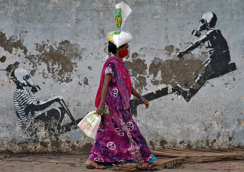 Người phụ nữ đeo khẩu trang khi đi bộ trên đường phố Mumbai hôm 12/6.