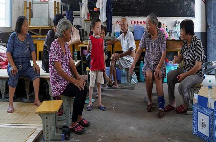 Hơn 2,2 triệu người dân đã phải sơ tán để đảm bảo an toàn. Ảnh: Người dân được sơ tán khỏi vùng ngập lụt ngồi nghỉ trong một phòng học của trường tiểu học ở Poyang, tỉnh Giang Tây, ngày 15/7.