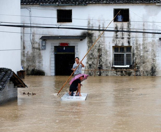 Người dân dùng bè di chuyển trong ngôi làng ngập lụt ở Hoàng Sơn, tỉnh An Huy.