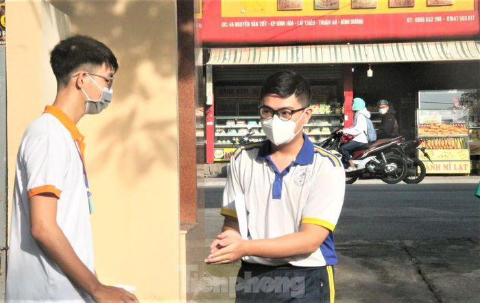 Học sinh được sát khuẩn và hướng dẫn đến khu vực làm thủ tục