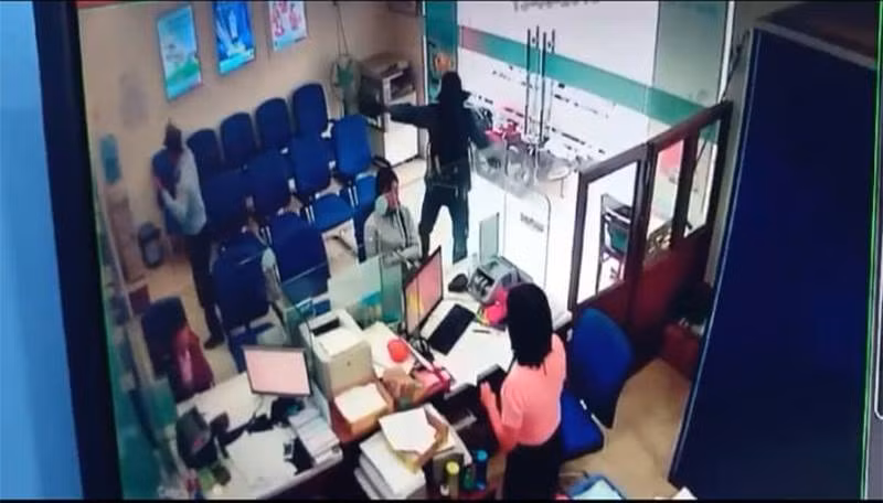 Hình ảnh nghi phạm giơ súng uy hiếp, cướp tiền trong ngân hàng