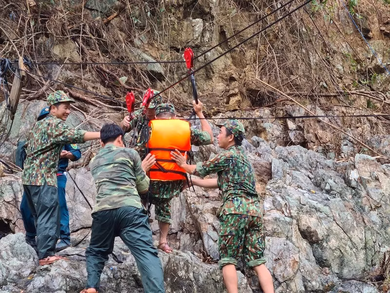  Bộ đội, dân quân túc trực hai đầu sẵn sàng đưa người qua lại khi cần. Việc đưa người qua sông bằng ròng rọc phải tuyệt đối đảm bảo an toàn. Ảnh: THANH NHẬT