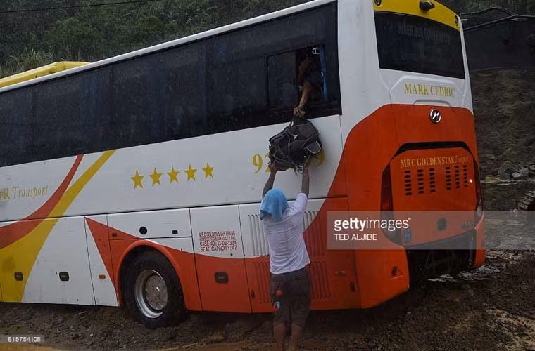 Chiếc xe chở khách bị kẹt trong đống bùn đất gây ra bởi một vụ sạt lở đất.