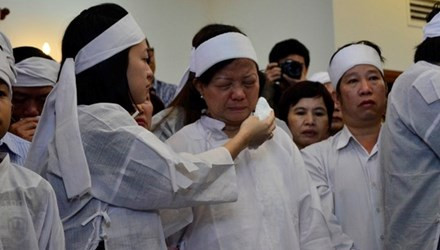 Con gái ông Nguyễn Bá Thanh lau nước mắt cho mẹ trong giờ truy điệu sáng 16/2.