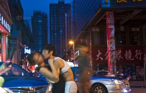 Tới nơi này, bạn có thể dễ dàng thấy những cảnh tượng “đặc sắc” như những cô gái làm bar đang ngồi ưỡn ẹo nói chuyện phiếm, những người đàn ông say rượu nằm ngủ ngay trên lan can vệ đường, thậm chí cả những cô gái làng chơi đang cò kè bớt một thêm hai khi đi khách. Ảnh: Một cô gái bán hoa cố gắng tránh né cái hôn bất ngờ từ khách hàng.