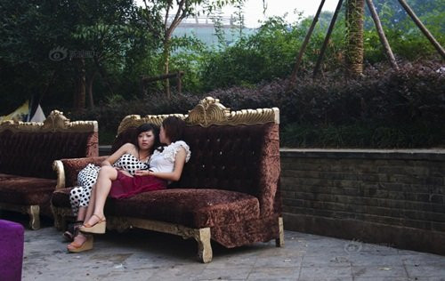 Đã từ lâu, tổ hợp thương mại trên con đường gần ga xe lửa Vô Tích là nơi tập trung nhiều thanh niên nam nữ sành điệu của thành phố. Con đường này nổi lên như một tụ điểm ăn chơi, nơi phô diễn những màn thời trang táo bạo cũng như những màn yêu đương nóng bỏng. Trong ảnh, hai cô gái làm ở bar đang ngồi tán chuyện trong khi rảnh rỗi.