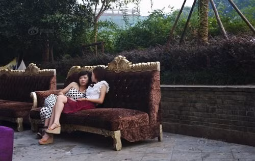 Đã từ lâu, tổ hợp thương mại trên con đường gần ga xe lửa Vô Tích là nơi tập trung nhiều thanh niên nam nữ sành điệu của thành phố. Con đường này nổi lên như một tụ điểm ăn chơi, nơi phô diễn những màn thời trang táo bạo cũng như những màn yêu đương nóng bỏng. Trong ảnh, hai cô gái làm ở bar đang ngồi tán chuyện trong khi rảnh rỗi.