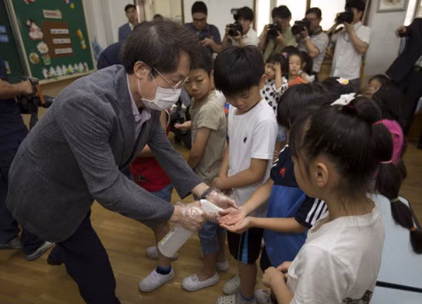 Ông Jo Hui Yeon, giám đốc sở giáo dục thành phố Seoul thực hiện hoạt động phòng dịch với các học sinh tiểu học tại trường tiểu học Gwanghui sáng ngày 17/6.