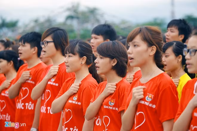 Các bạn trẻ nghiêm trang cùng nhau hát bài "Tiến quân ca" của nhạc sĩ Văn Cao.