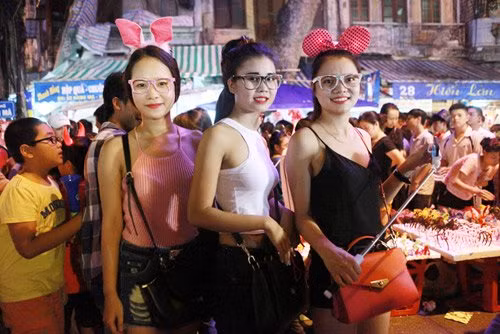 Một tốp các bạn gái lựa chọn áo yếm, áo 2 dây để xua tan cái nóng trên phố Hàng Mã.