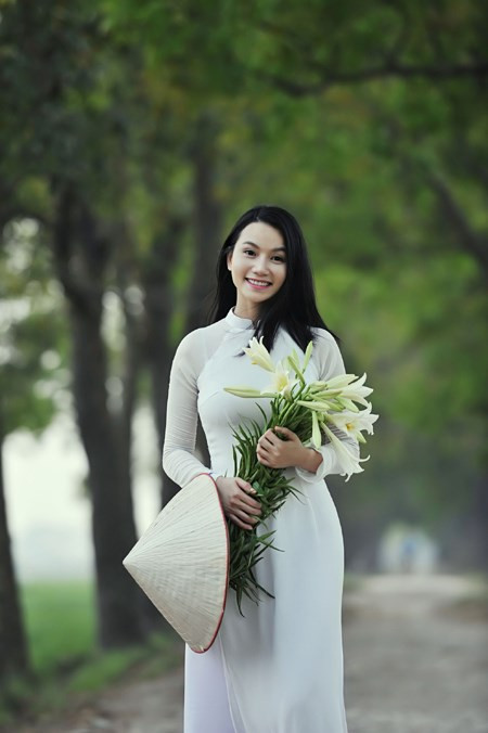 Tà áo dài trắng tinh khôi cùng sắc trắng tinh khiết của hoa loa kèn càng tôn thêm vẻ đẹp e ấp, dịu dàng mà cũng rất đỗi kiêu sa của cô gái đa tài Lương Giang.