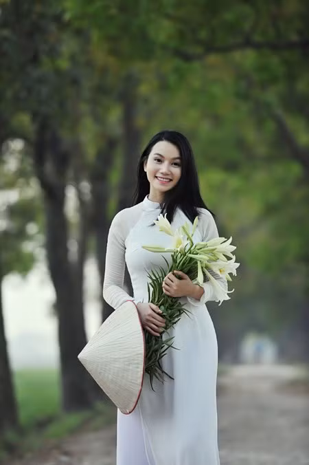 Tà áo dài trắng tinh khôi cùng sắc trắng tinh khiết của hoa loa kèn càng tôn thêm vẻ đẹp e ấp, dịu dàng mà cũng rất đỗi kiêu sa của cô gái đa tài Lương Giang.