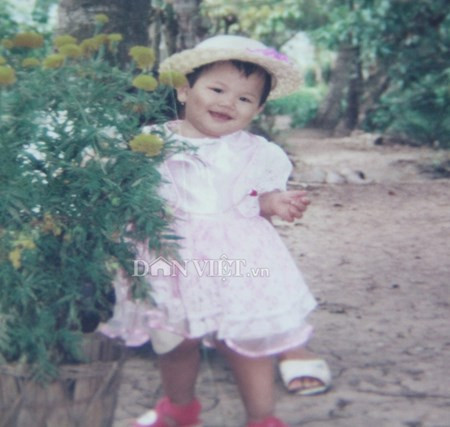 Điều khiến chúng tôi hết sức bất ngờ là trái ngược hẳn với vẻ gầy gò, đen sạm bây giờ, Ánh Viên ngày bé khá trắng trẻo, bầu bĩnh đến đáng yêu. Trong ảnh, lúc 1 tuổi, Ánh Viên đã biết "tạo dáng" bên hoa.