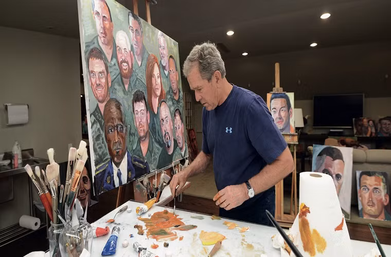 Cựu Tổng thống Mỹ Bush ăn mặc giản dị đang hoàn thành một bức vẽ.