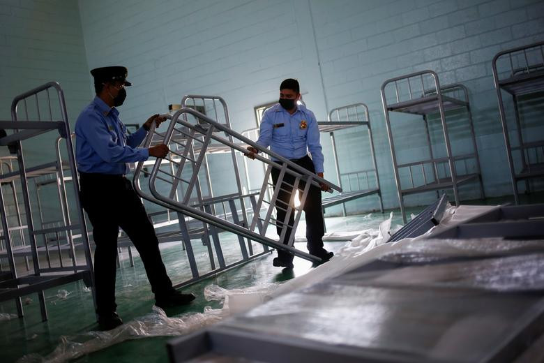 Nhân viên cứu hỏa lắp giường tầng bên trong một phòng tập gym được sử dụng làm nơi ở tạm thời cho những người di cư đến từ Trung Mỹ bị trục xuất khỏi Mỹ, tại Ciudad Juarez, ngày 3/4/2021.