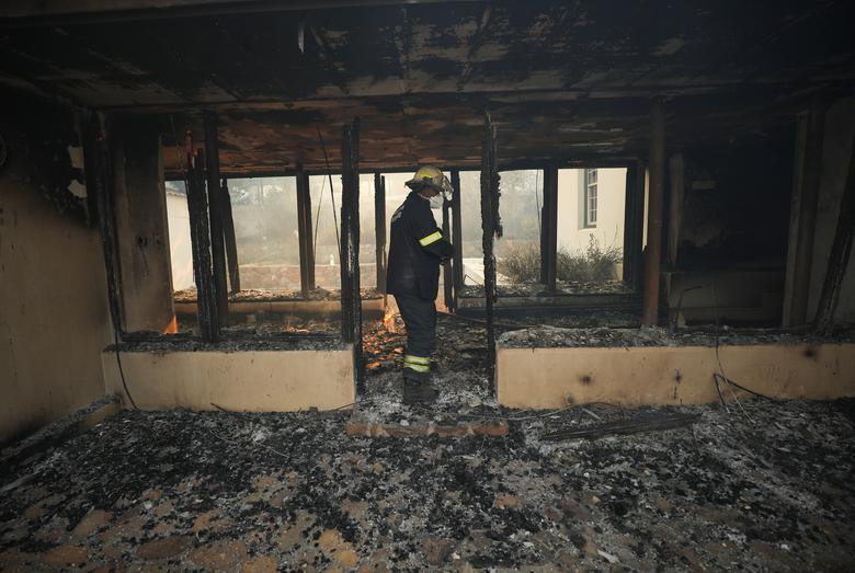 Lính cứu hỏa bên trong một công trình bị hư hại do vụ cháy.